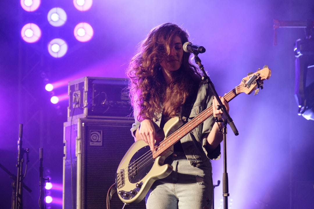 feminist musician playing bass guitar on music festival or concert